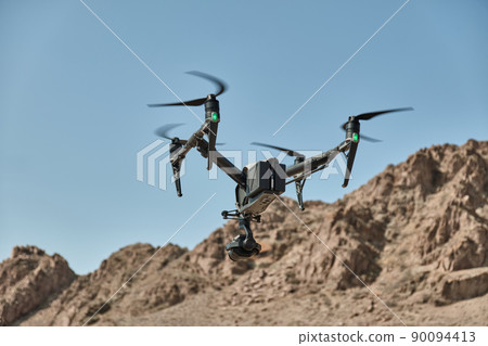 A professional drone flies and shoots a video, 90094413