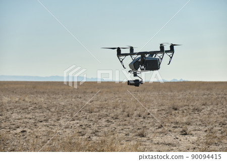 A professional drone flies and shoots a video, 90094415