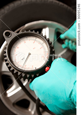 Car Tire Pressure Check in the Auto Service Garage. Checking and filling air in the tire at service station. Car Tire Pressure Check in the Auto Service Garage. Checking and filling air in the tire at service station. 90095246