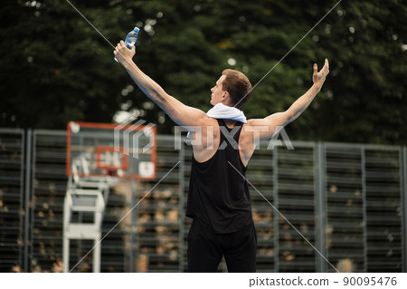 Muscular young man in sport clothes standing with hands aside on outdoor city gym Muscular young man in sport clothes standing with hands aside on outdoor city gym 90095476