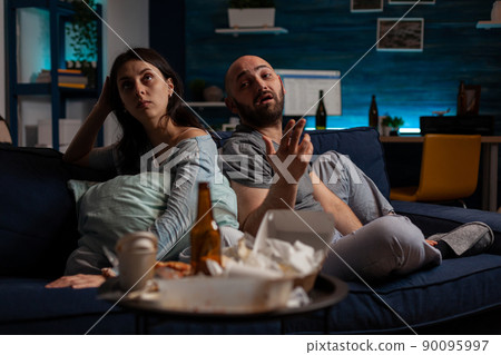 Angry boyfriend and girlfriend having argument on couch, dealing with mental health difficulties and being in conflict about anxiety. Frustrated man and woman arguing about depression and negativity. Angry boyfriend and girlfriend having argument on couch, dealing with mental health difficulties and being in conflict about anxiety. Frustrated man and woman arguing about depression and negativity. 90095997