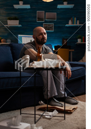 Anxious displeased man dealing with sadness and depression, having mental health illness difficulties and feeling pensive in messy living room. Depressed frustrated person with disease. Anxious displeased man dealing with sadness and depression, having mental health illness difficulties and feeling pensive in messy living room. Depressed frustrated person with disease. 90096008