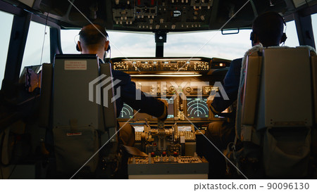 Captain and copilot throttling engine handle to fly airplane, taking off with international airline plane. Using control panel command on dashboard and switching navigation in cockpit. Handheld shot. Captain and copilot throttling engine handle to fly airplane, taking off with international airline plane. Using control panel command on dashboard and switching navigation in cockpit. Handheld shot. 90096130