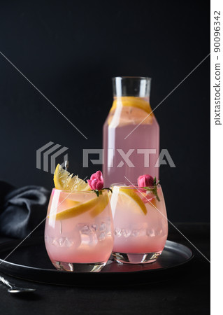 Cocktails with pink rose gin and lemon on black background. Cocktails with pink rose gin and lemon on black background. 90096342