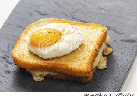 toast with cheese served with fried egg 90096389