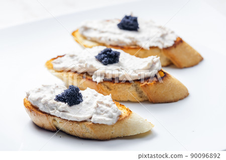 toasted baguette with tuna spread and black caviar 90096892