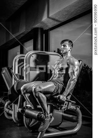 Leg Exercises - Man Doing Leg With Machine In Gym 90096990