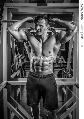Handsome man with big muscles, posing at the camera in the gym Handsome man with big muscles, posing at the camera in the gym 90097025