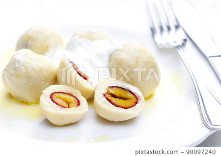 plum dumplings with sour cream, powder sugar and melted butter 90097240