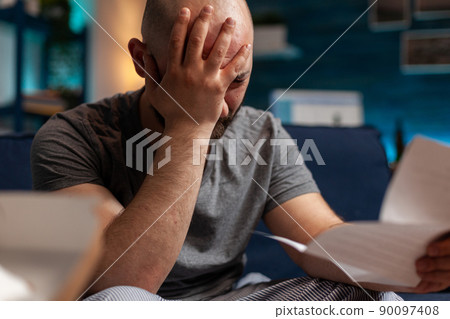 Worried person with depression reading eviction notice paper, feeling frustrated about mortgage payment and financial debt. Sad anxious man receiving bank bill warning notification. Close up. 90097408