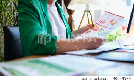 Businesswoman studies analytical business charts in office Businesswoman studies analytical business charts in office 90099529