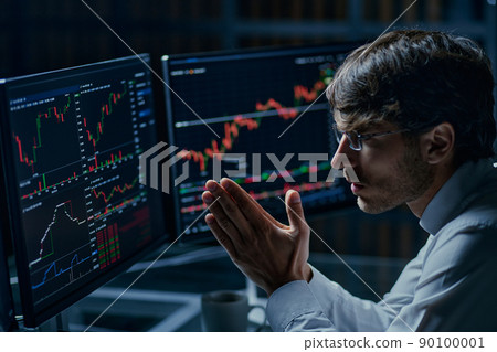businessman looking at computer monitors with stock market data . businessman looking at computer monitors with stock market data . 90100001