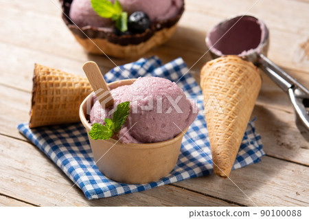 Blueberry ice cream scoops with waffle on wooden table Blueberry ice cream scoops with waffle on wooden table 90100088
