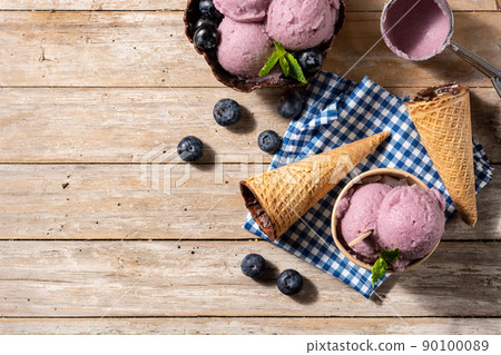Blueberry ice cream scoops with waffle on wooden table Blueberry ice cream scoops with waffle on wooden table 90100089