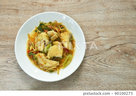 spicy fried Asian redtail catfish with herb and chili on plate 90100273