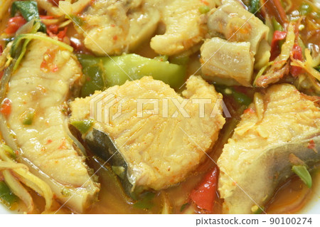 spicy fried Asian redtail catfish with herb and chili on plate 90100274