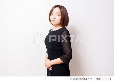 Woman in mourning dress standing in front of white background 90100491
