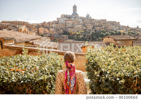 woman walks on background of cityscape of Siena old town in Italy woman walks on background of cityscape of Siena old town in Italy 90100668