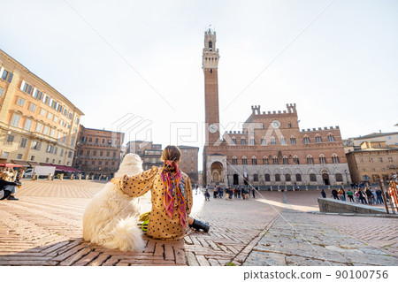 Woman traveling with dog at Siena town in Italy Woman traveling with dog at Siena town in Italy 90100756