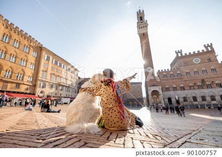Woman traveling with dog at Siena town in Italy Woman traveling with dog at Siena town in Italy 90100757