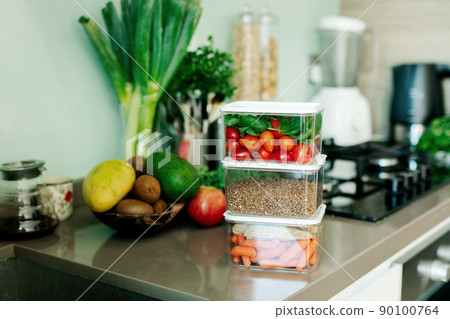 Fresh various vegetables and buckwheat in a container are on the table in the kitchen, the food is ready to eat. Fresh various vegetables and buckwheat in a container are on the table in the kitchen, the food is ready to eat. 90100764