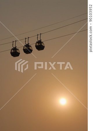 Sihouette of cable cars against the sky with evening sun. Sihouette of cable cars against the sky with evening sun. 90103952