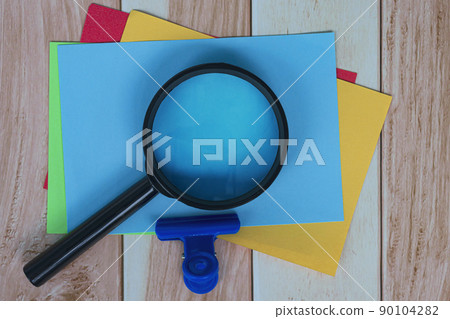 Colorful Adhesive Note With Magnifying Glass On Wooden Desk. Business Concept. Colorful Adhesive Note With Magnifying Glass On Wooden Desk. Business Concept. 90104282