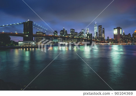 Brooklyn Bridge at Night with Water Reflection in New York City Brooklyn Bridge at Night with Water Reflection in New York City 90104369