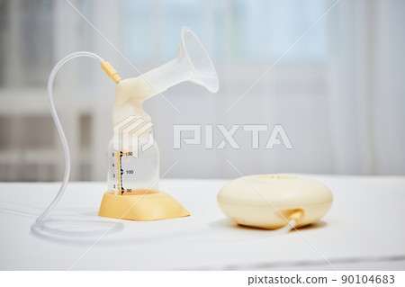 Breast pump with empty baby bottle on table 90104683