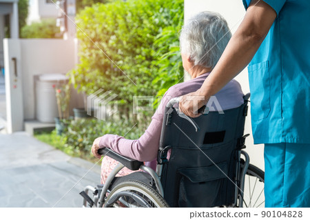 Caregiver help and care Asian senior or elderly old lady woman patient sitting in wheelchair on ramp at nursing hospital, healthy strong medical concept 90104828
