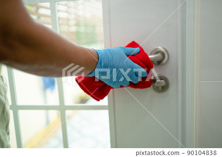 Cleaning door handle with cloth at office and home for protect covid 19 coronavirus 90104838
