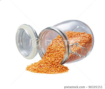Raw red lentils spill out of a glass storage jar isolated on white background. Raw red lentils spill out of a glass storage jar isolated on white background. 90105151