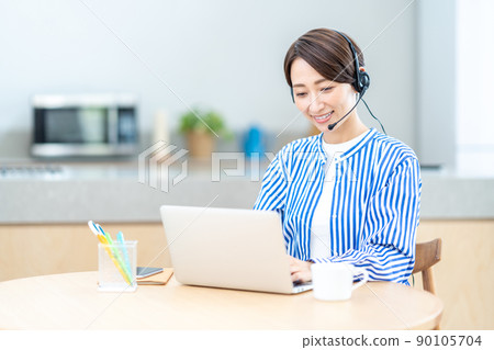 Middle-aged woman taking an online seminar in the living room Middle-aged woman taking an online seminar in the living room 90105704