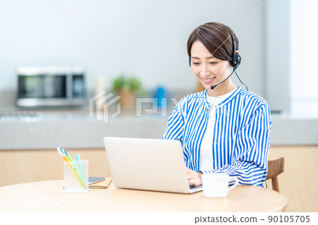 Middle-aged woman taking an online seminar in the living room Middle-aged woman taking an online seminar in the living room 90105705