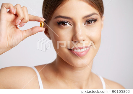 Close Up Of Happy Woman Holding Pill With Cod Liver Oil Omega-3 Close Up Of Happy Woman Holding Pill With Cod Liver Oil Omega-3 90105803