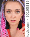Close-up face portrait of original style young woman who has colorful hair 90105819