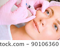 Image of a young beautiful woman dressed as a patient, lying on a couch in a cosmetology clinic. 90106360