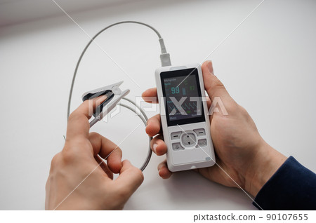 Man using finger pulse oximeter, healthcare monitoring concept. Pulse oximeter on a white background 90107655