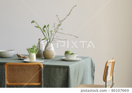 Elegant table setting with cherry brunch in craft vase , cherimoya fruits, fennel and ginger root in craft ceramic plates on linen tablecloth. Outdoor table setting for summer holiday concept. 90107669