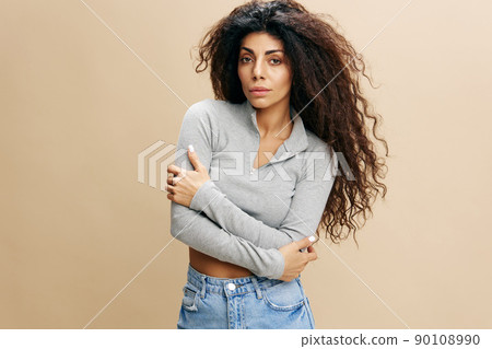 GOOD OFFER. Confident serious pretty Latin female with afro folded arms, crossing hand, hugging herself, laughing, stay isolated over yellow background. Copy space, free place, fashion banner GOOD OFFER. Confident serious pretty Latin female with afro folded arms, crossing hand, hugging herself, laughing, stay isolated over yellow background. Copy space, free place, fashion banner 90108990