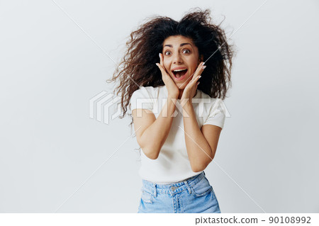 SUMMER SALE. Surprised curly Latin woman stay isolated look at camera, recline on hands smile, say Wow. Copy place for fashion brands, free space for advertising. Studio shooting white background 90108992