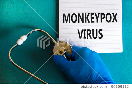 Monkeypox virus symbol. Concept words Monkeypox virus on white note. Stethoscope. Doctor hand in blue glove with white note. Medical and Monkeypox virus concept. Copy space. 90109312