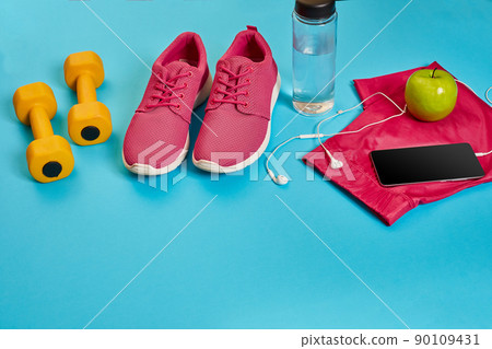 Healthy concept, diet plan with sport shoes and bottle of water and dumbbells on blue background, healthy food and exercise concept 90109431
