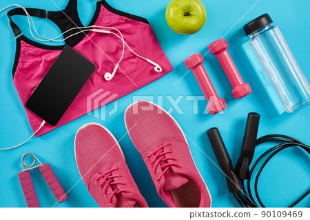 Athlete's set with female clothing, dumbbells and bottle of water on bright blue background 90109469