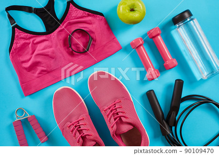 Athlete's set with female clothing, dumbbells and bottle of water on bright blue background 90109470