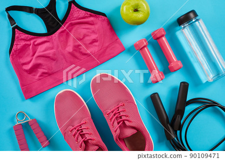 Athlete's set with female clothing, dumbbells and bottle of water on bright blue background 90109471