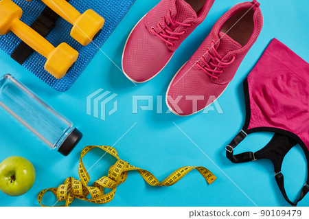 Athlete's set with female clothing, dumbbells and bottle of water on bright blue background Athlete's set with female clothing, dumbbells and bottle of water on bright blue background 90109479
