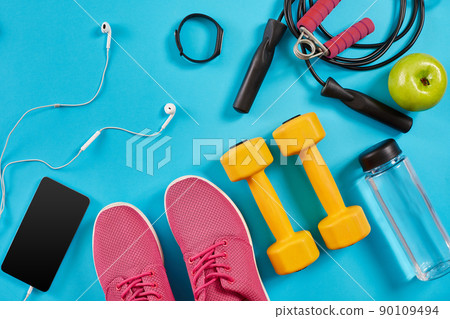 Athlete's set with female clothing, dumbbells and bottle of water on bright blue background Athlete's set with female clothing, dumbbells and bottle of water on bright blue background 90109494