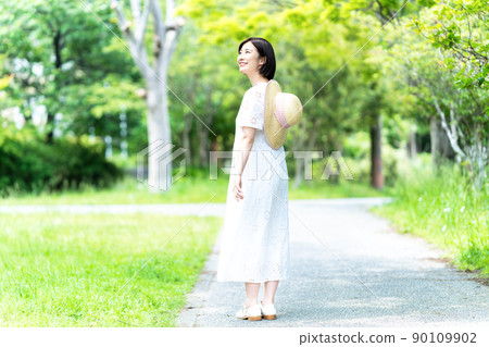 A young woman strolling through the fresh green 90109902