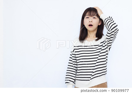 A woman in her thirties holding her head A woman in her thirties holding her head 90109977